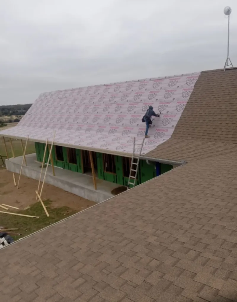 Worker preparing underlayment for a metal roof installation in Chesterfield